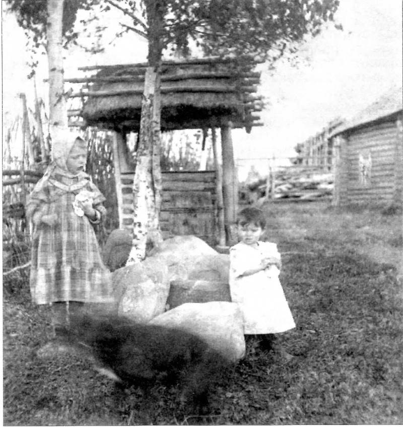 Деревня Платуново. Девочки Лена Чистякова и Оля Озерова у колодца под соломенной крышей. До 1917 года.
